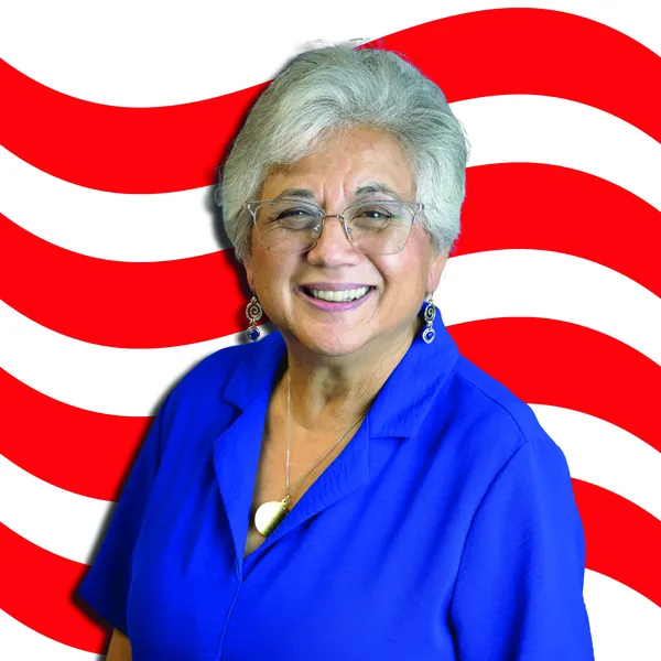 Anna Munson in a blue blouse smiling, with red-and-white waves behind her